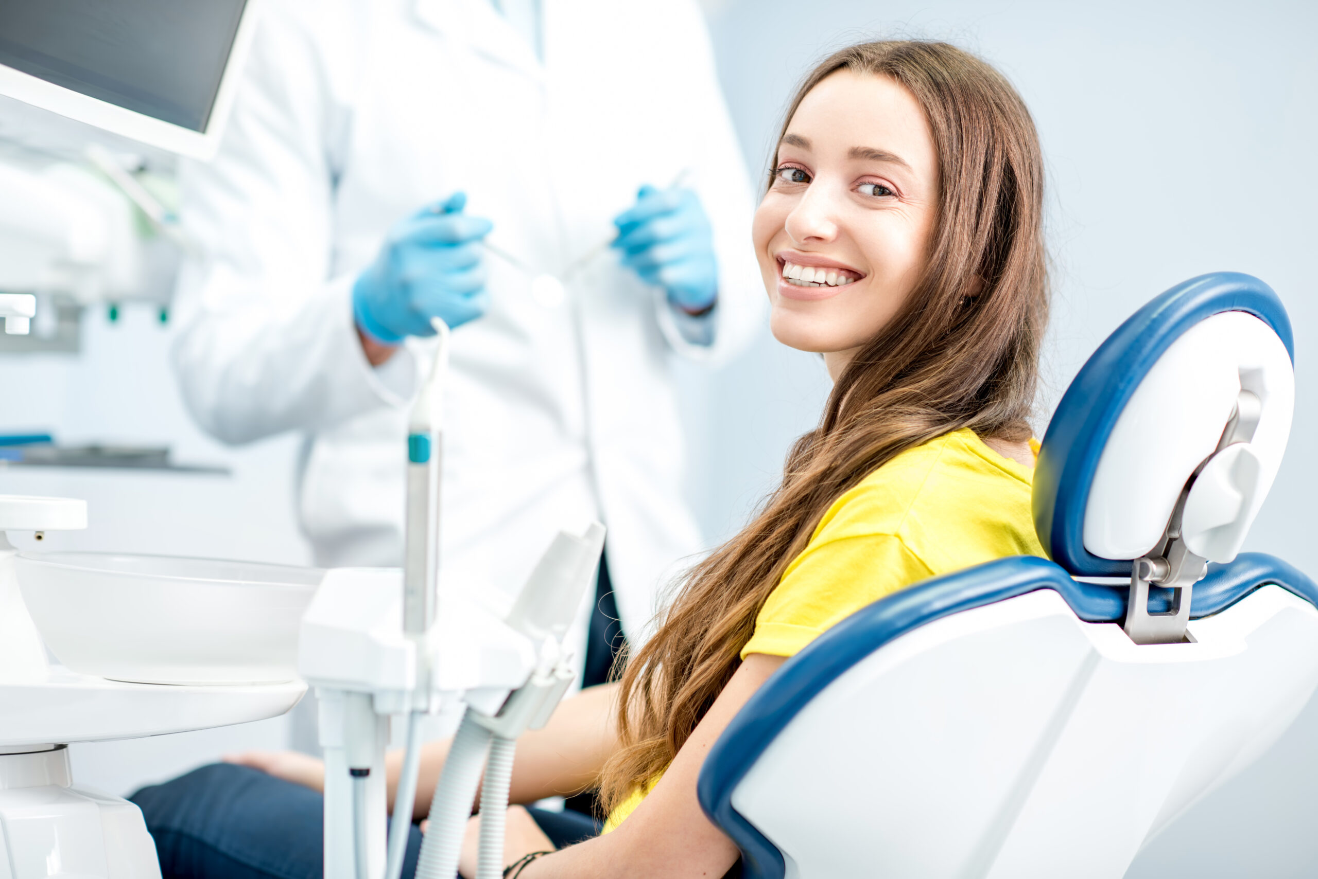 Zahnarztpatientin lächelt mit einem strahlenden Lächeln in die Kamera
